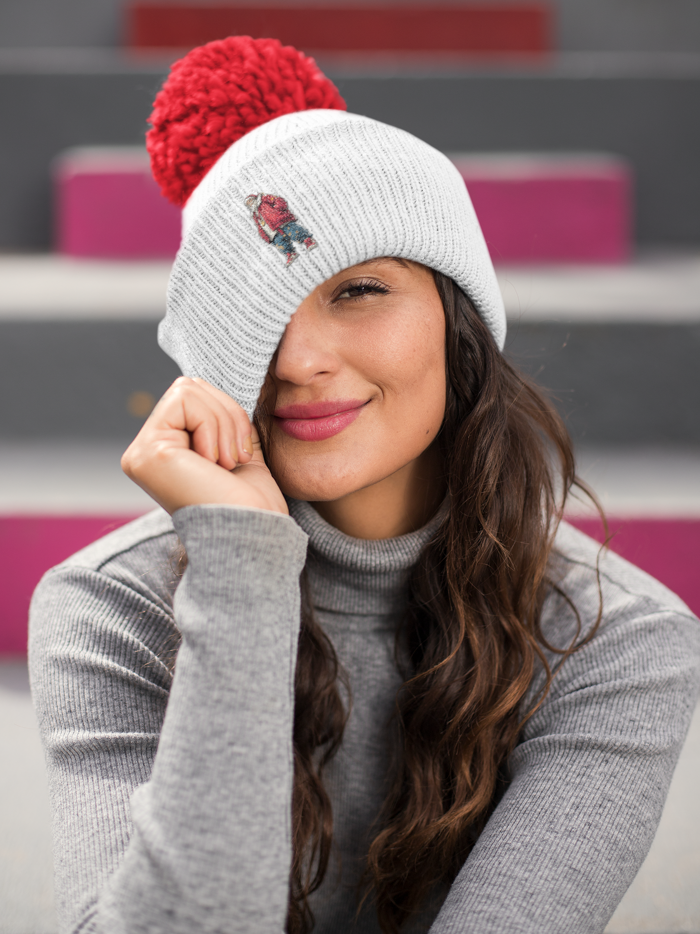 Weihnachtlicher Beanie Mockup – Frau mit grauer Mütze und rotem Bommel im urbanen Winter Look.